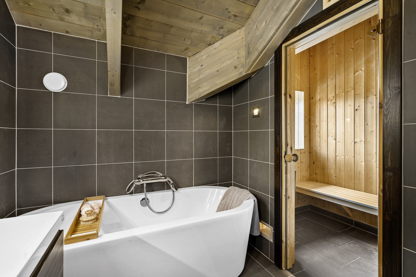 Badet i forbindelse med hovedsoverommet. Servant med skuffer under, badekar, dusjhjørne, wc og badstue. Galleribilde