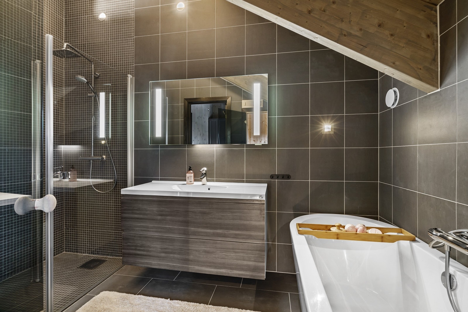 Badet i forbindelse med hovedsoverommet. Servant med skuffer under, badekar, dusjhjørne, wc og badstue. Galleribilde