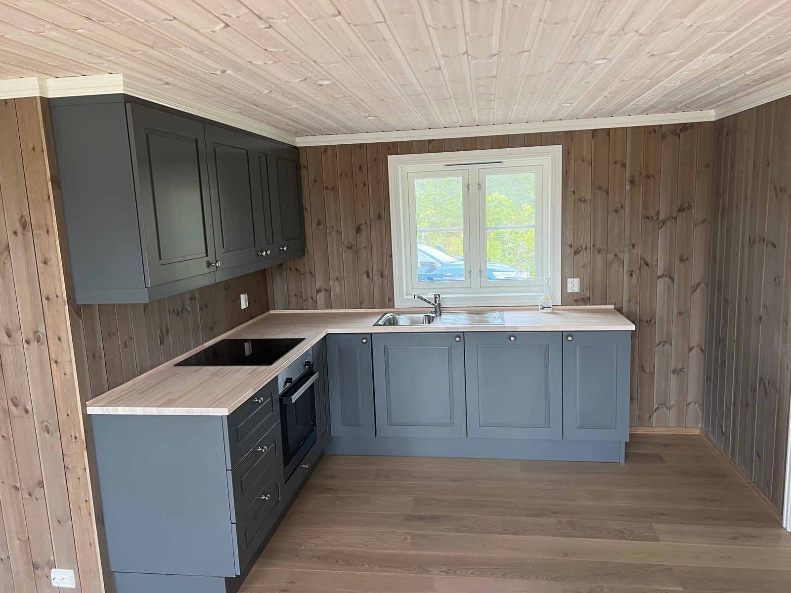 Kjøkken med integrerte hvitevarer (oppvask, komfyr, induksjonstopp, ventilator) og plass for kjøl/frys Galleribilde