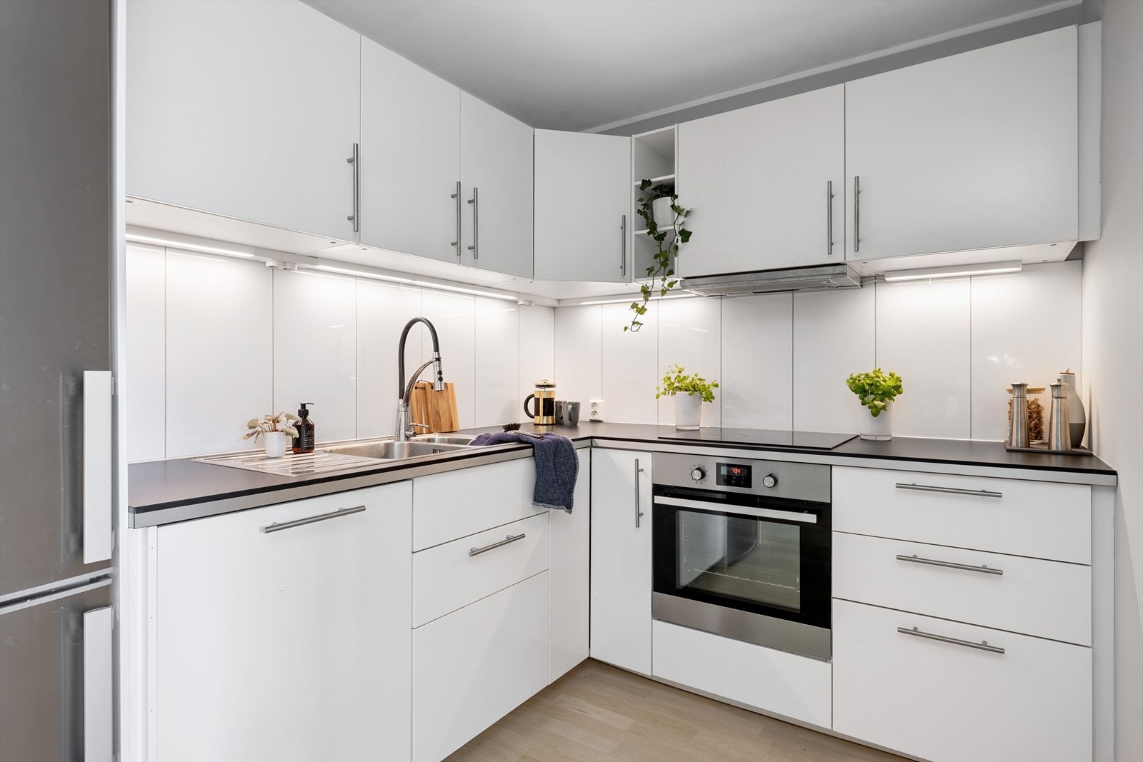 Det er lekre fliser mellom benk og overskap, samt belysning og stikkontakter under overskap Galleribilde