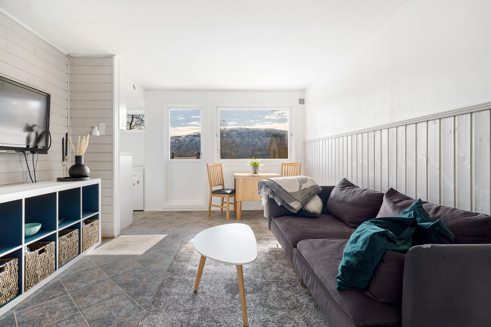 Stue malt i lune farger og har god plass til å etablere flere hyggelige soner.