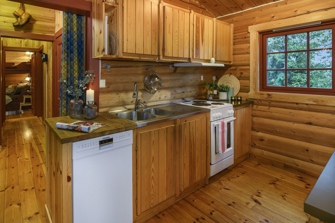 Benkebeslag i stål med ett-greps blandebatteri, komfyr og oppvaskmaskin. Alle hvitevarer medfølger i salget Galleribilde