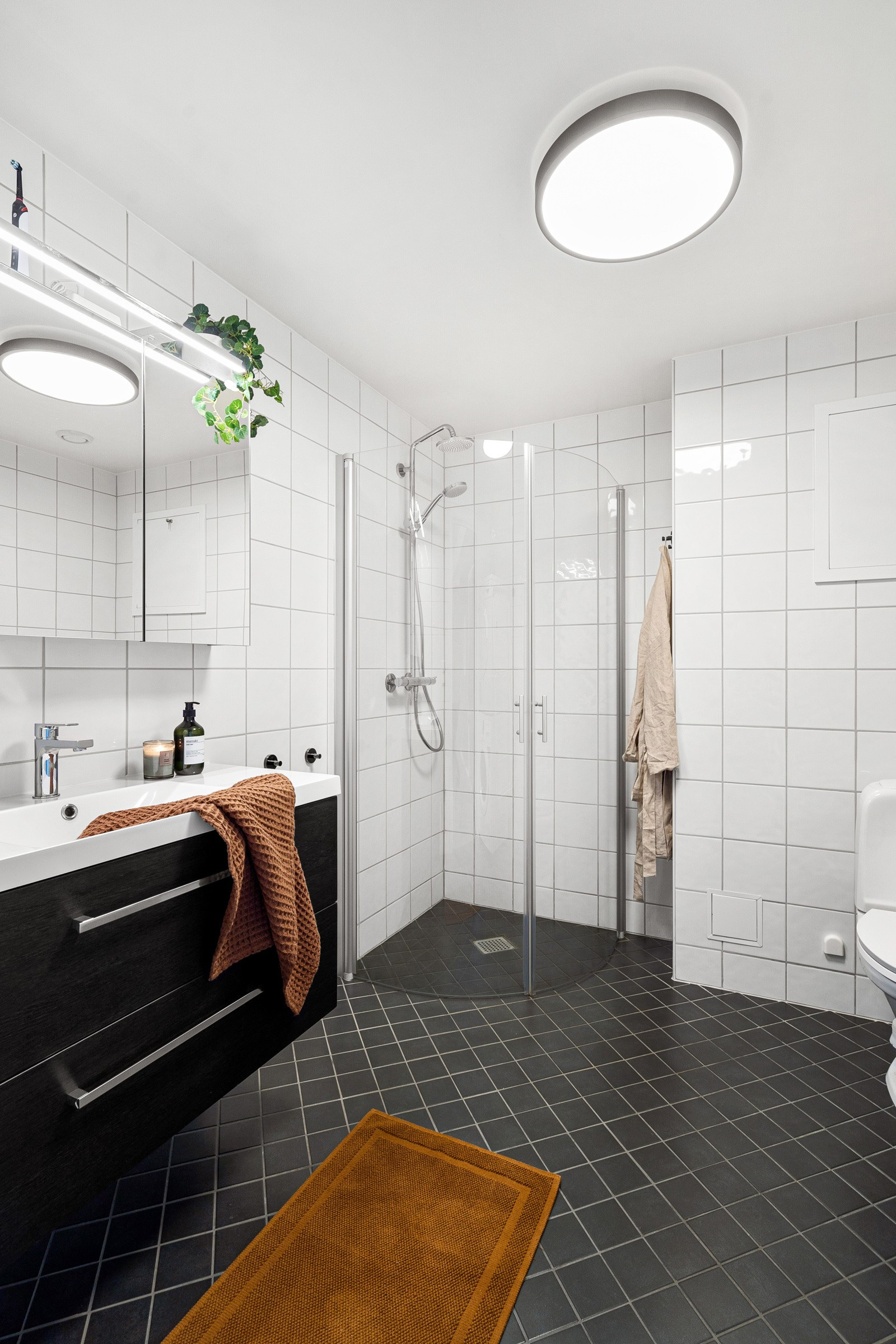 Komplett flislagt bad med ny og moderne innredning, overspeil med belysning og skuffer samt dusjhjørne.