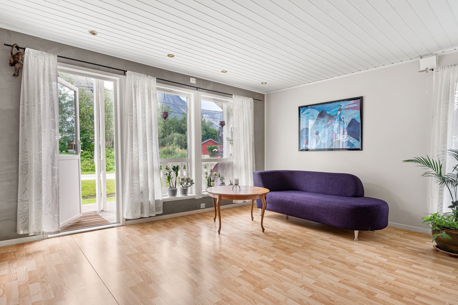 Stuen har store vinduer som sikrer rikelig med innslipp av naturlig lys. Fra stuen er det utgang til stor veranda.
