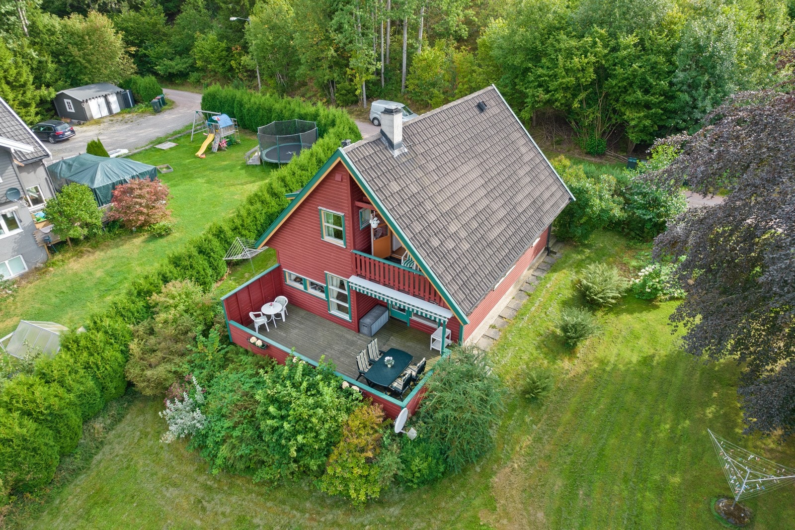 Svakt skrånende tomt opparbeidet med plenarealer og diverse beplantning. Galleribilde