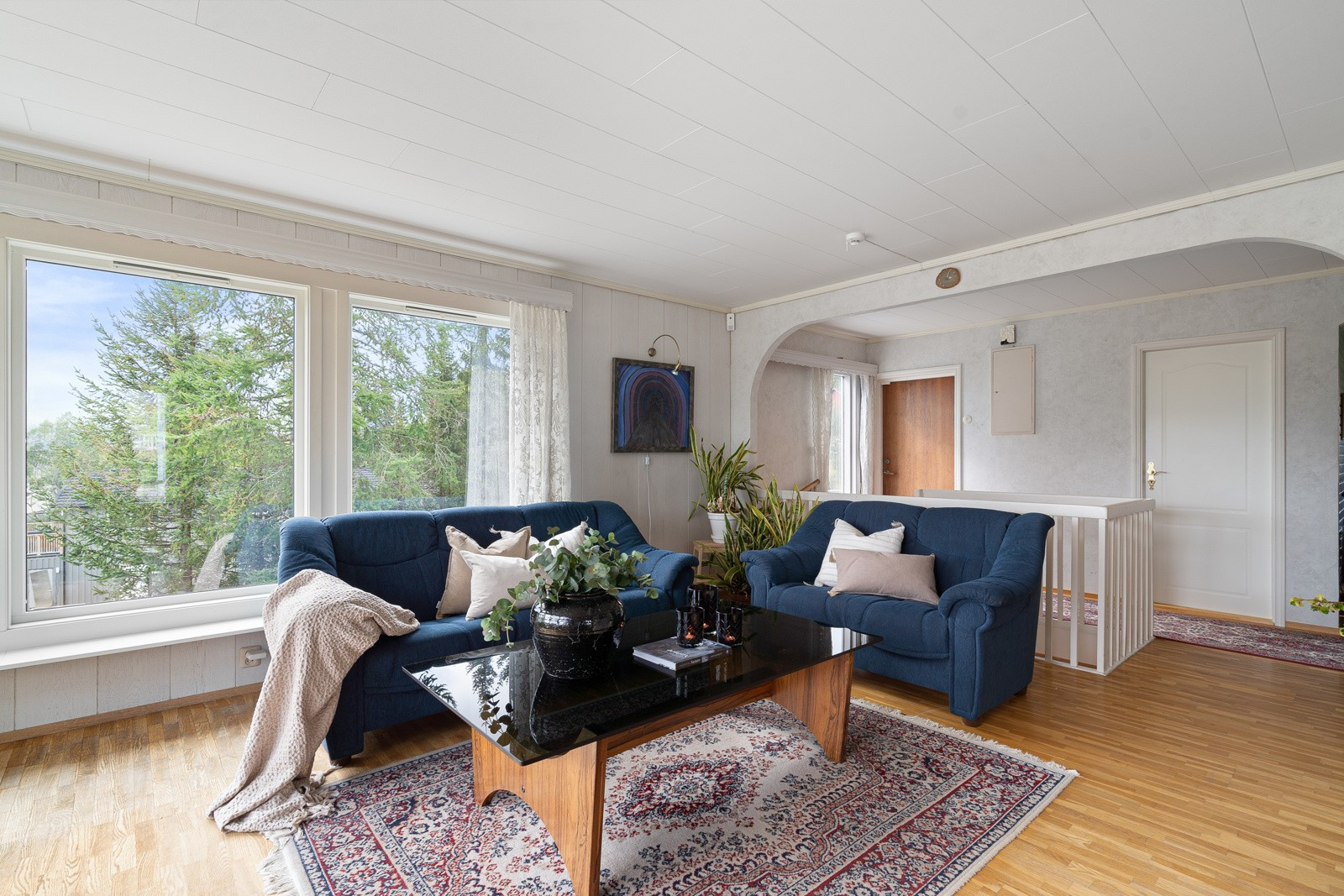 Boligens stue er lys og innbydende og har stor plass til å etablere sosiale soner.