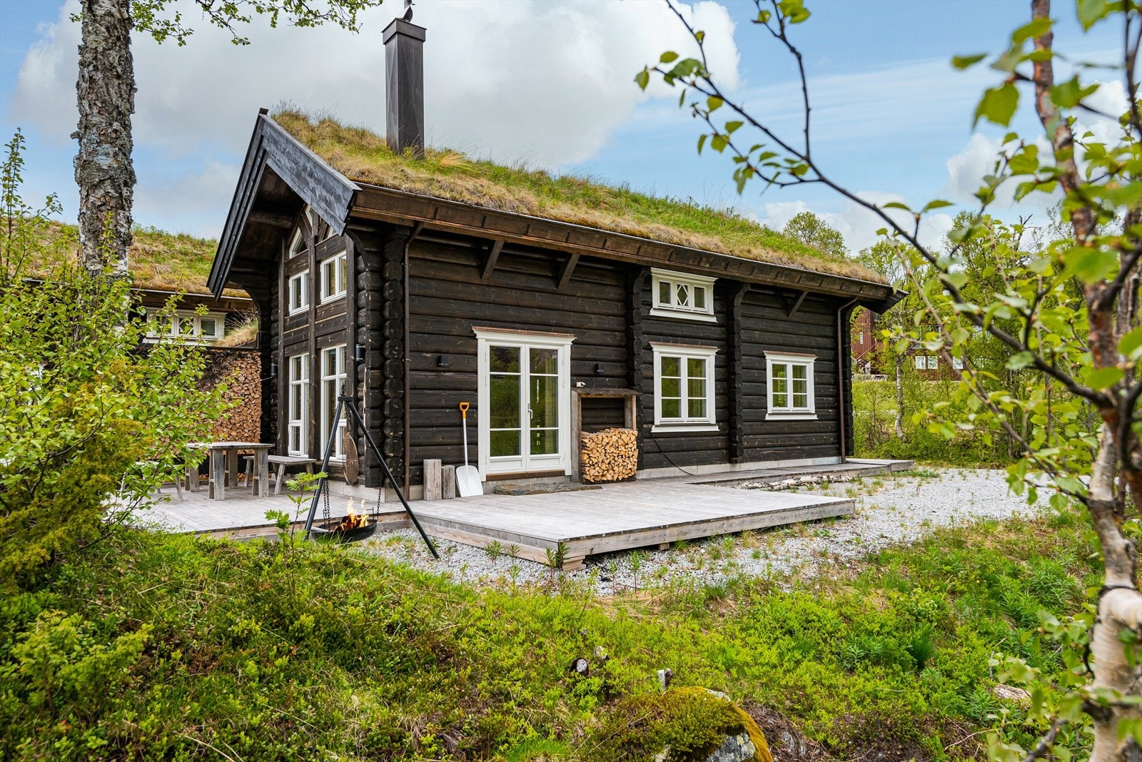 Hytta holder et sjarmerende, tradisjonelt uttrykk med laftet tømmer og torvtak Galleribilde