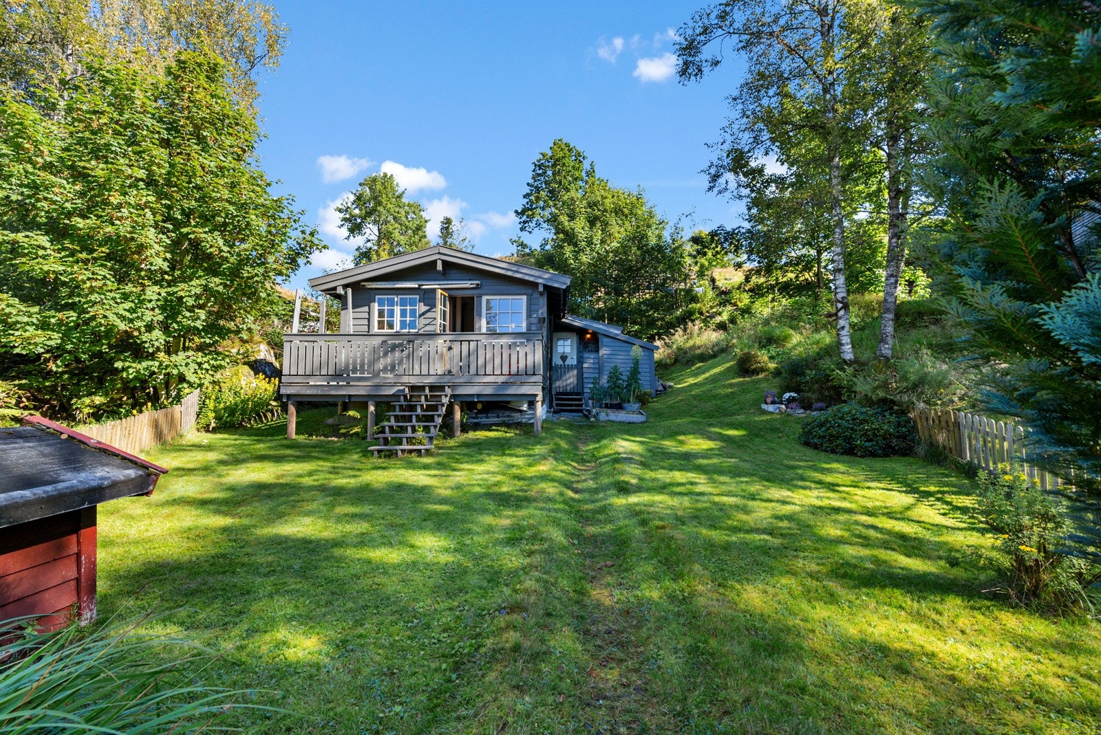 Rundt boligen er det opparbeidet hage med plenarealer og div. beplantning Galleribilde