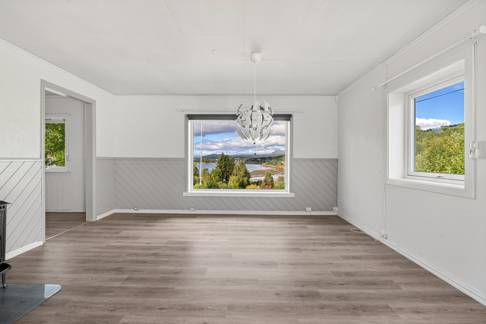 Boligens stue er lys og innbydende med store vindusflater som sikrer rikelig med innslipp av naturlig lys.