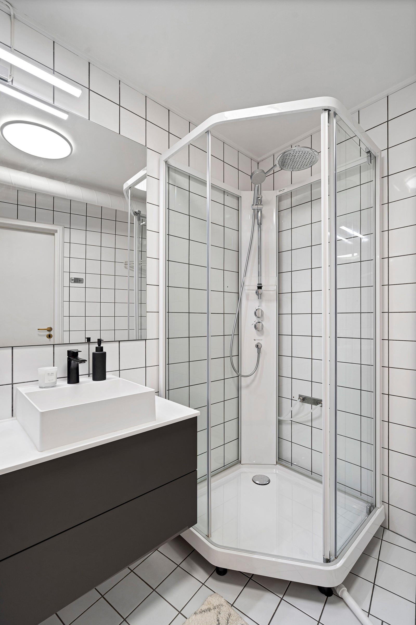 Badet er innredet med servant, dusjkabinett og toalett
