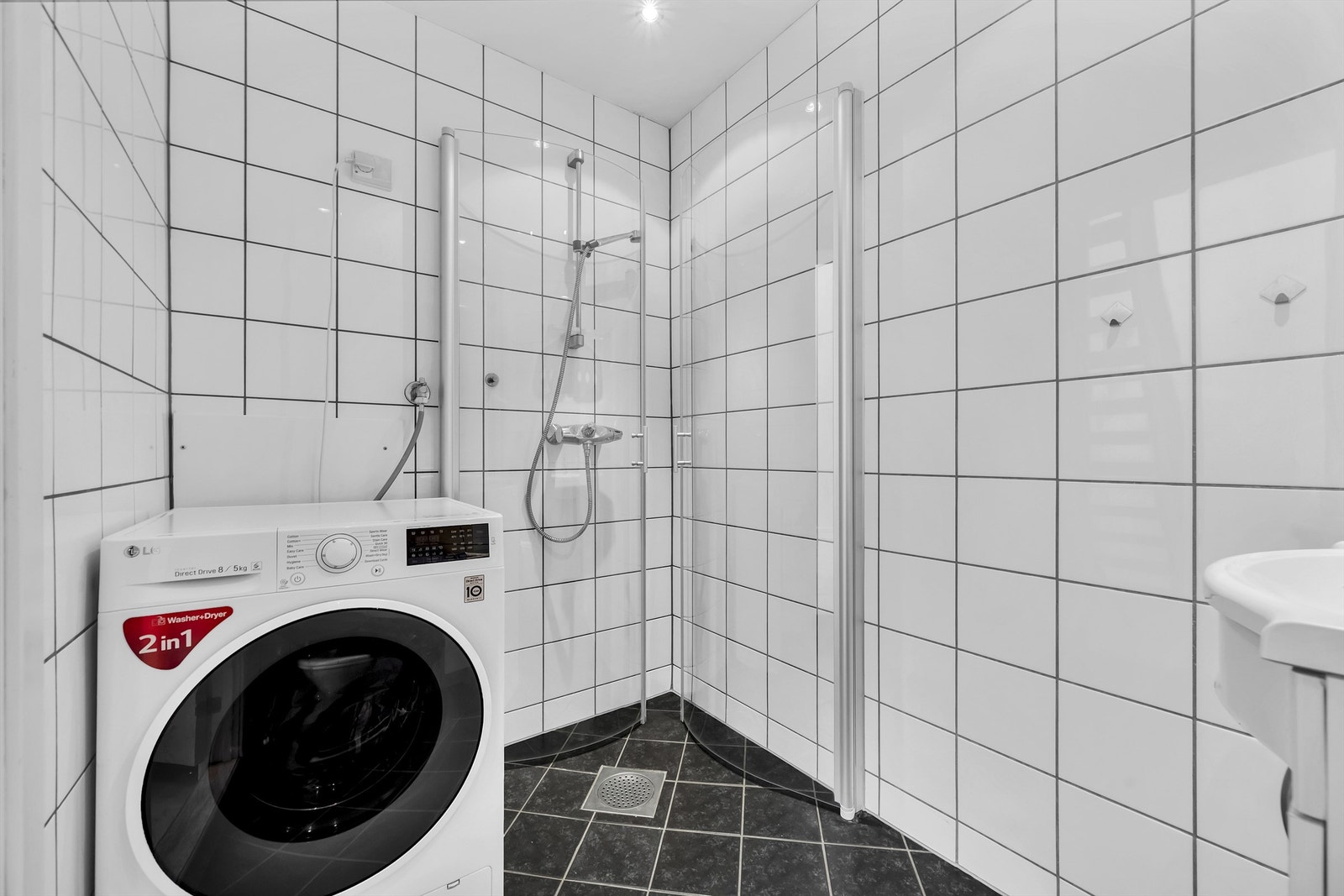 Videre har badet dusjhjørne med innfellbare dører i herdet glass med sluk i støpejern. Galleribilde