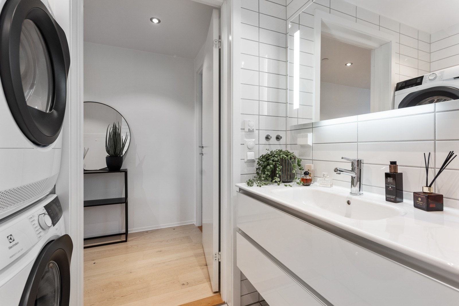 Romslig og pent bad med opplegg for vaskemaskin og tørketrommel, gulvvareme og downlights i himling Galleribilde