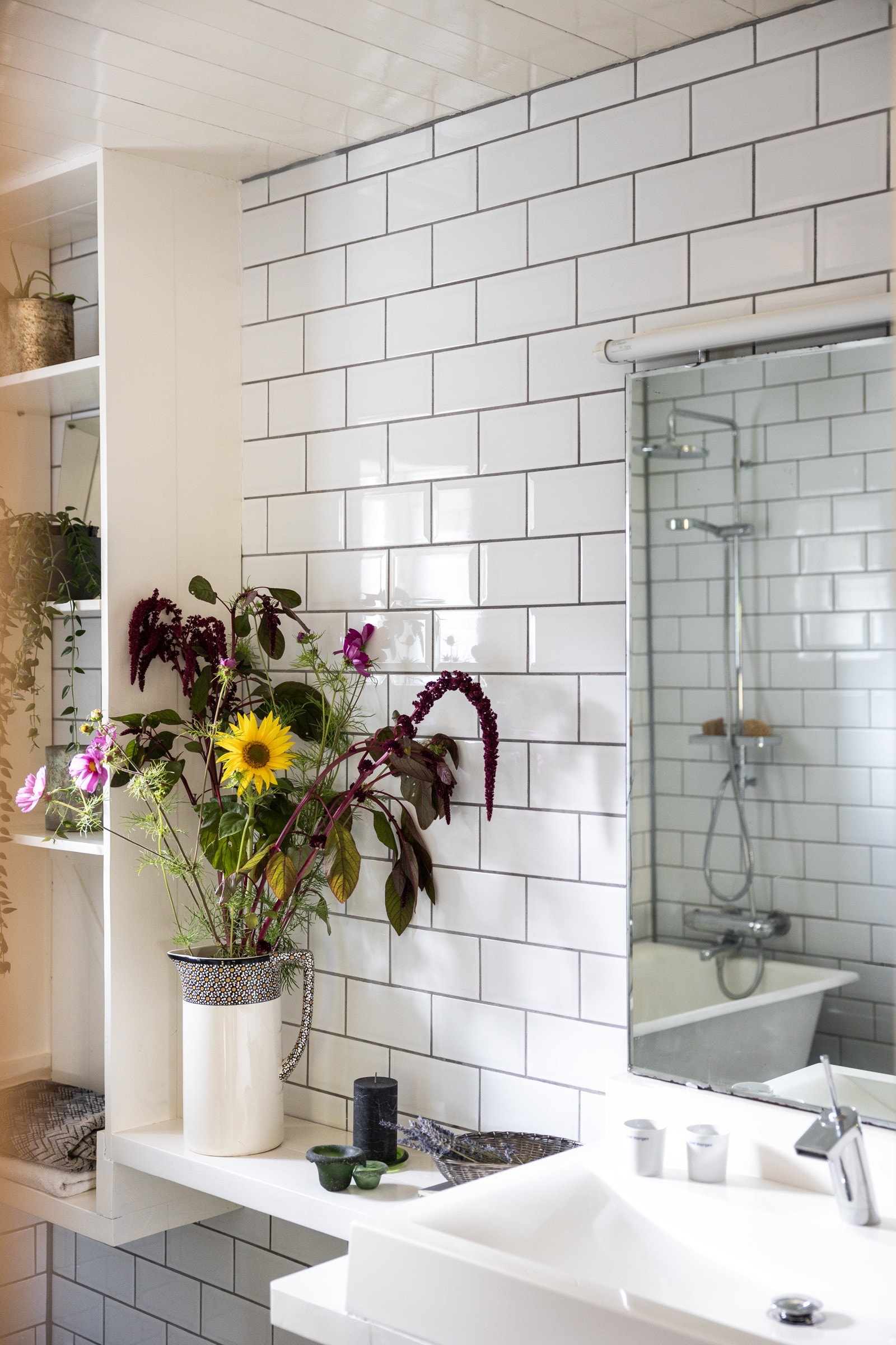 Badet har plassbygde hyller, speil over servant, dusj i badekar, servant og toalett. Galleribilde