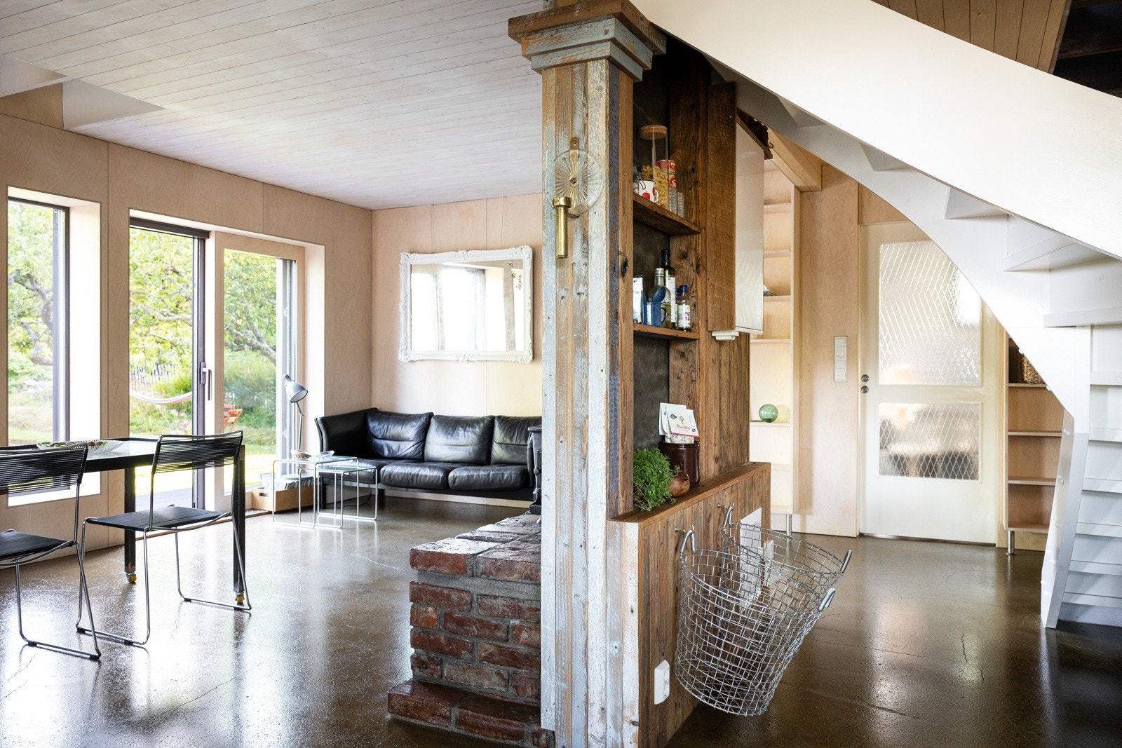 Lekker stue med store vinduer og eksponert betong på gulv som er overflatebehandlet med olje. Galleribilde