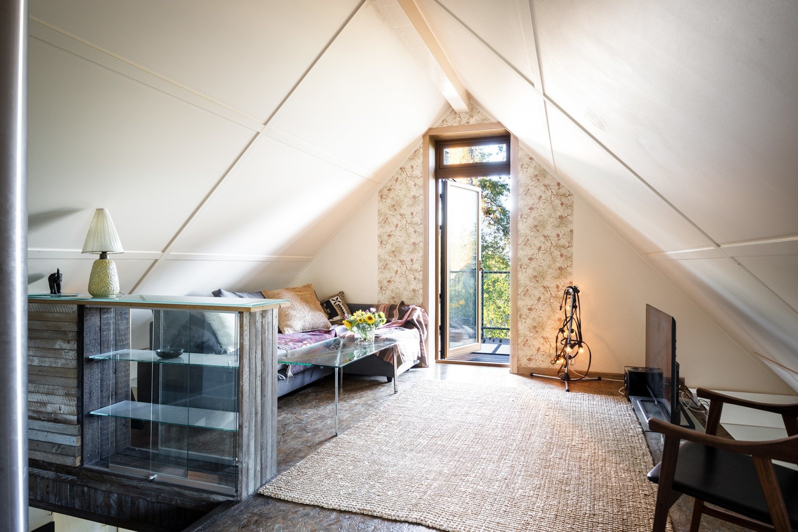 TV-stue i 2. etasje med skråtak og gulv med plater i beiset tre. Galleribilde