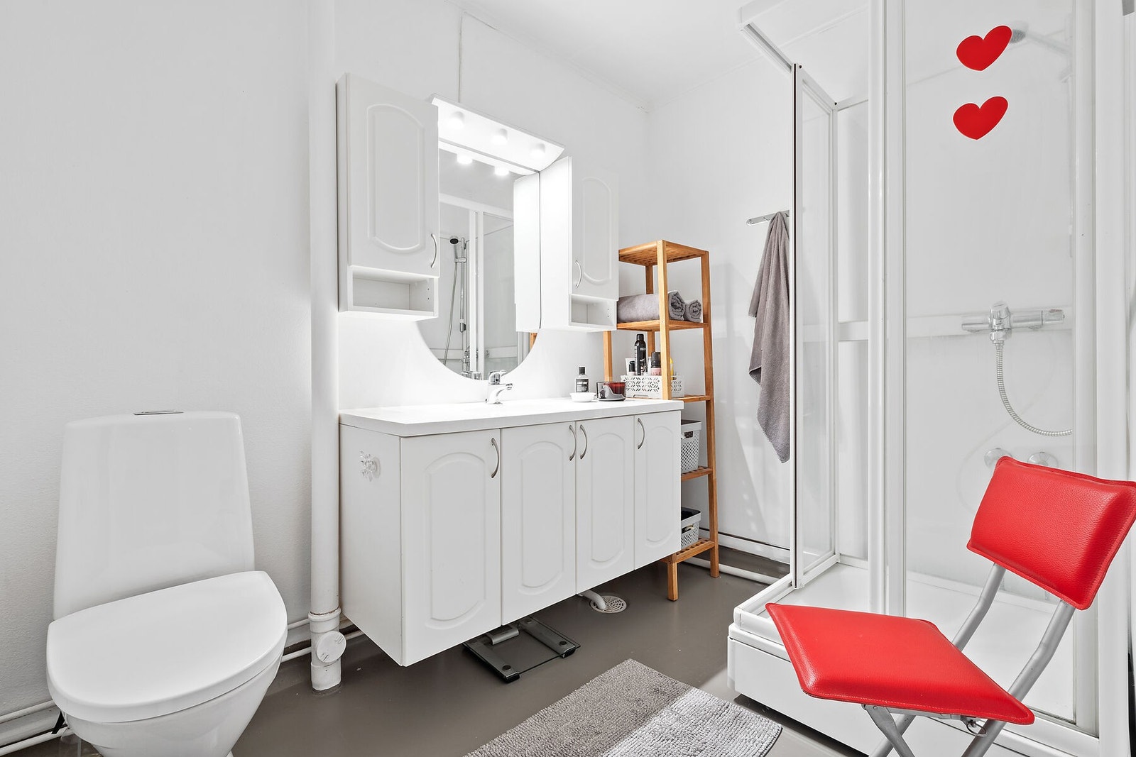 Lyst bad med hvit profilert innredning og dusjkabinet. Galleribilde