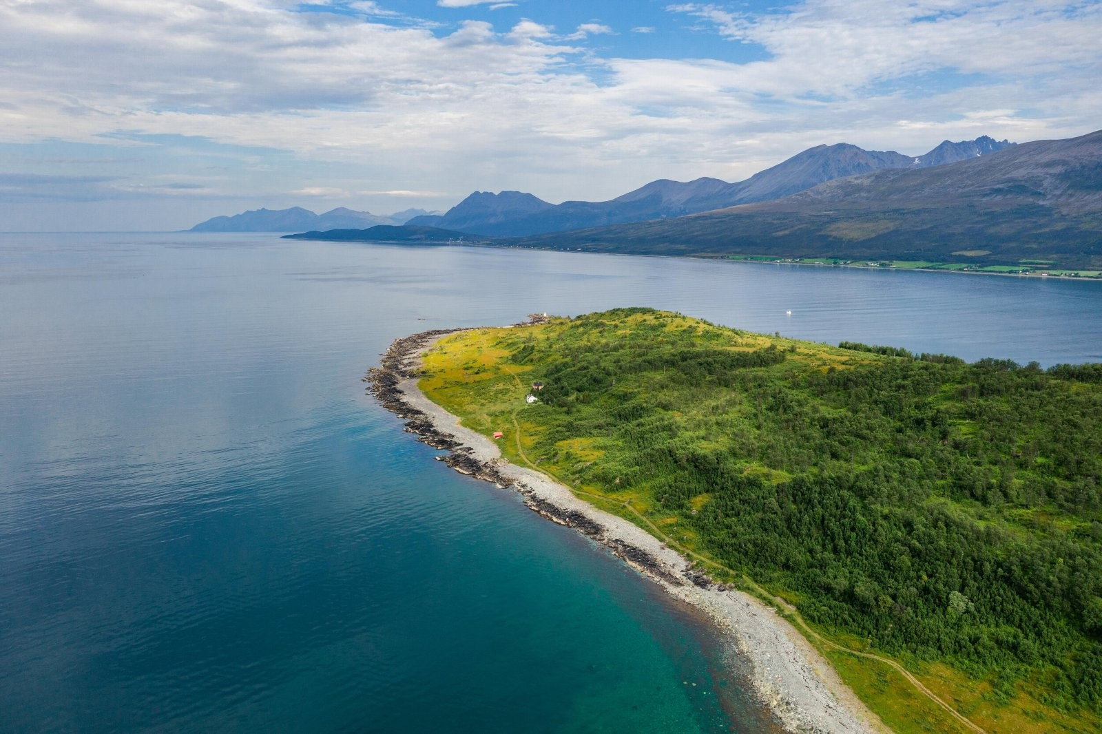 Der ingen skulle tru, nokon kunne bu! Eiendommen ligger spektakulært plassert i ensom majestet ytterst mot vest. I bakgrunnen ser du bl.a. Storgalten og Russelvtinden. En av flere toppturklassikere i Lyngsalpene.
