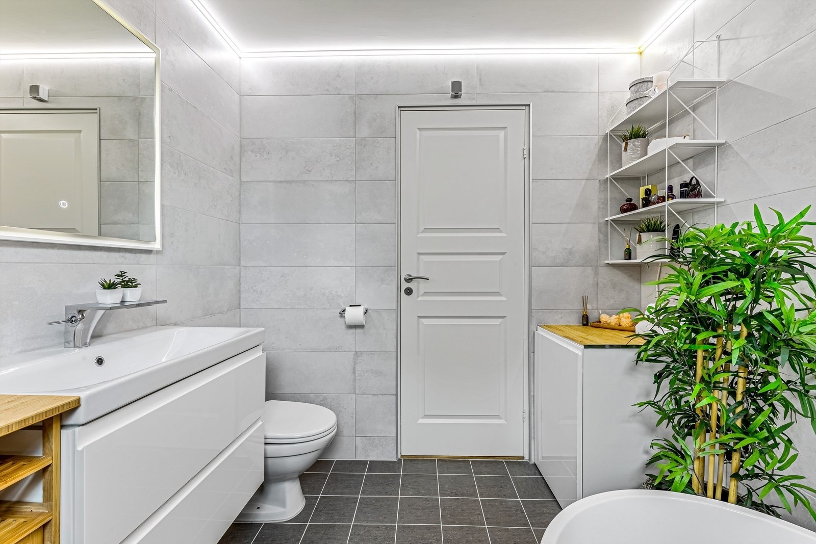 Innredet med servantskap, toalett, badekar og opplegg for vaskemaskin. Galleribilde