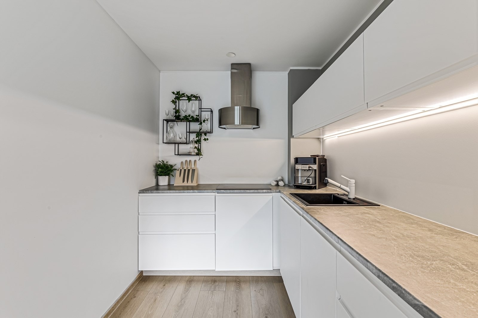 Kjøkkeninnredning med glatte fronter og laminat benkeplaten. I Galleribilde