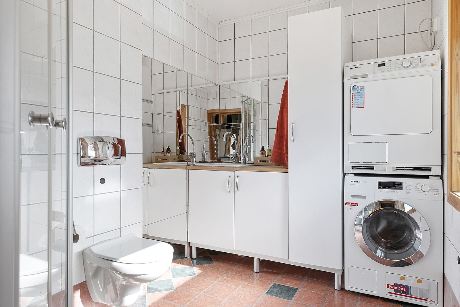 Badet i 1. etasje er flislagt og har vegghengt toalett og opplegg til vaskemaskin og tørketrommel. Galleribilde