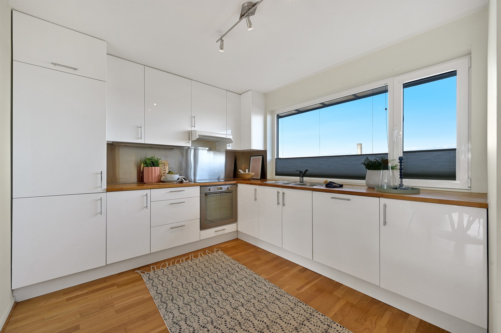 Kjøkkenet har integrerte hvitevarer og godt med skap- og benkeplass Galleribilde