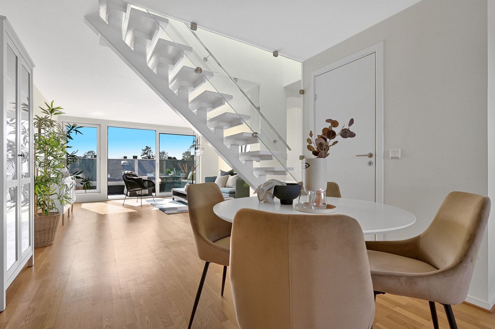 Romslig stue hvor glasset på balkongen gjør at man har utsikt ut over byen fra sofakroken Galleribilde