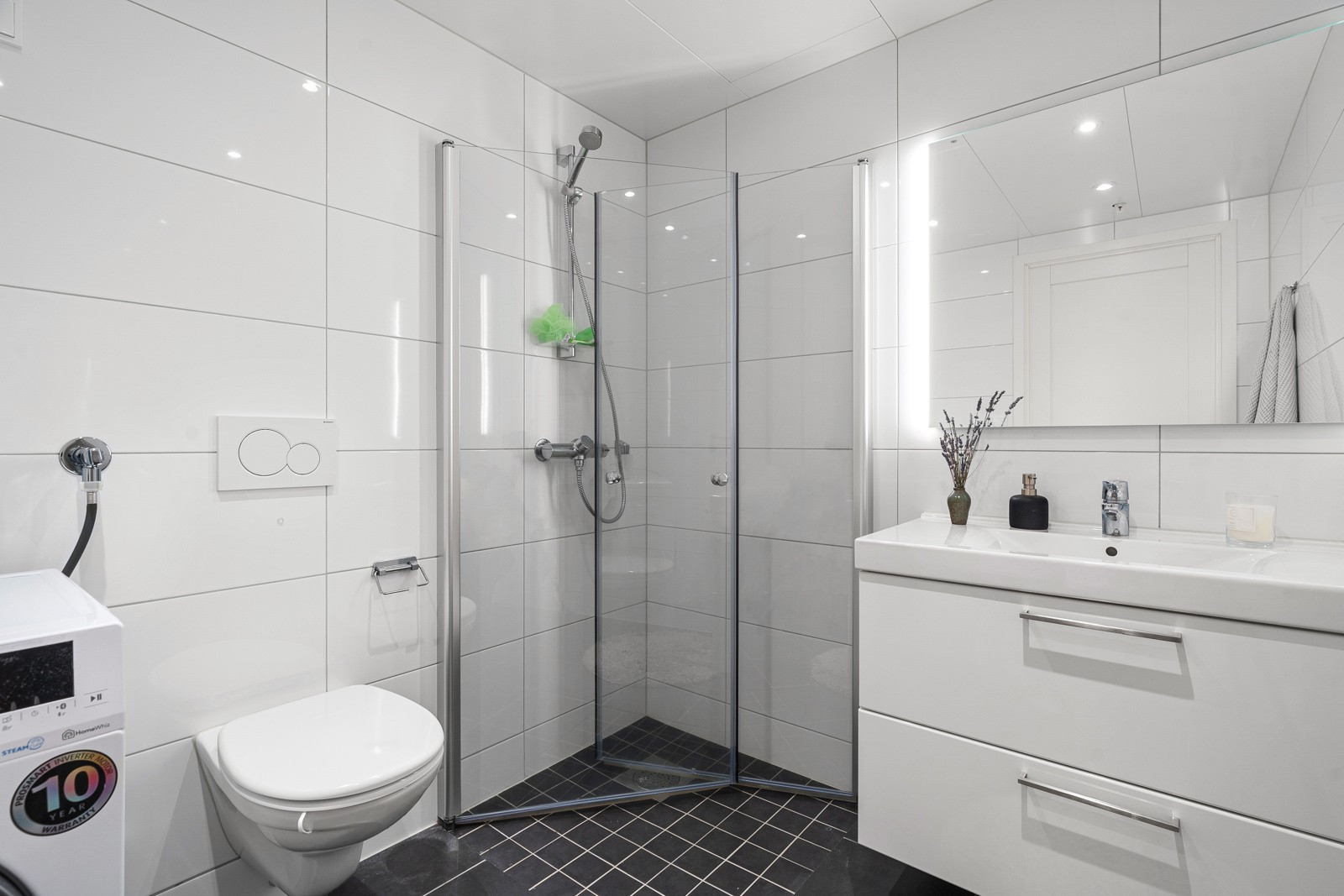 Badet inneholder dusjnisje, romslig baderomsinnredning og opplegg for vask/tørk.