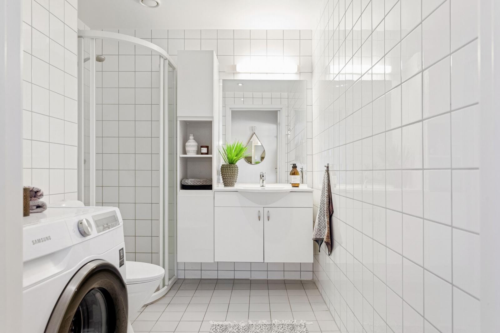 Romslig bad fra 2006 med tidløse fliser. Det er varme i gulv og opplegg for vaskemaskin og tørketrommel. Galleribilde