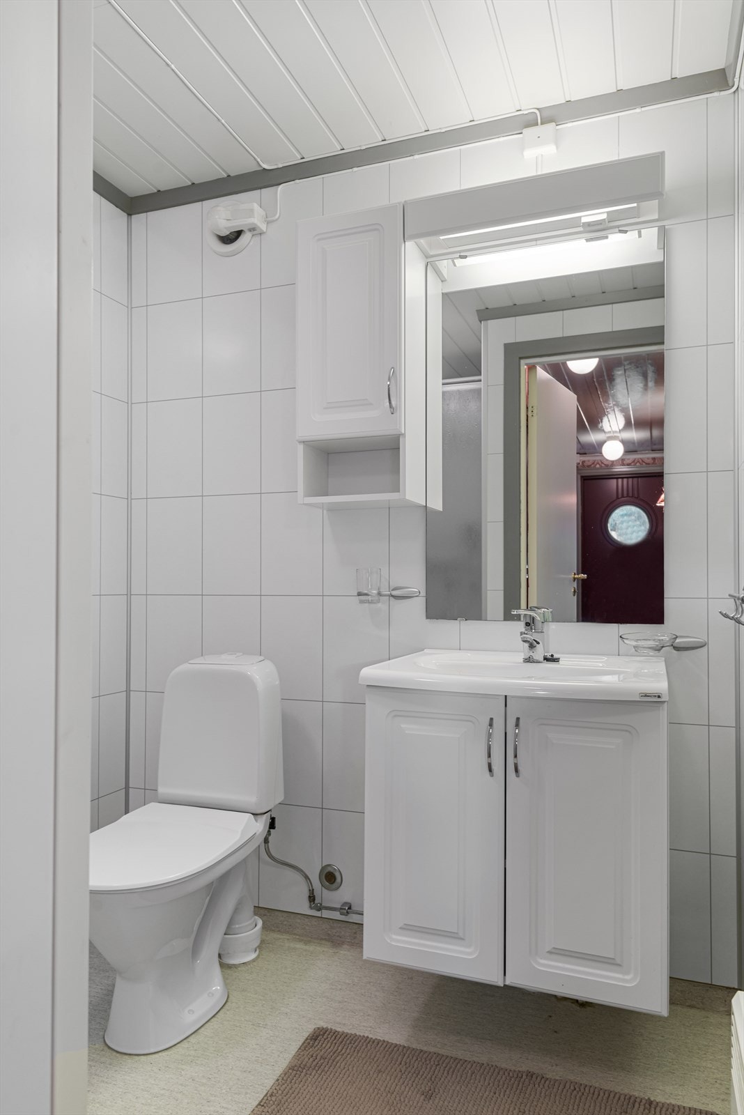 Badet ble oppgradert i 2009, og har innredning med lyse profilerte fronter, overskap og speil. Rommet er lyst og pent, og har dusjkabinett og toalett. Galleribilde