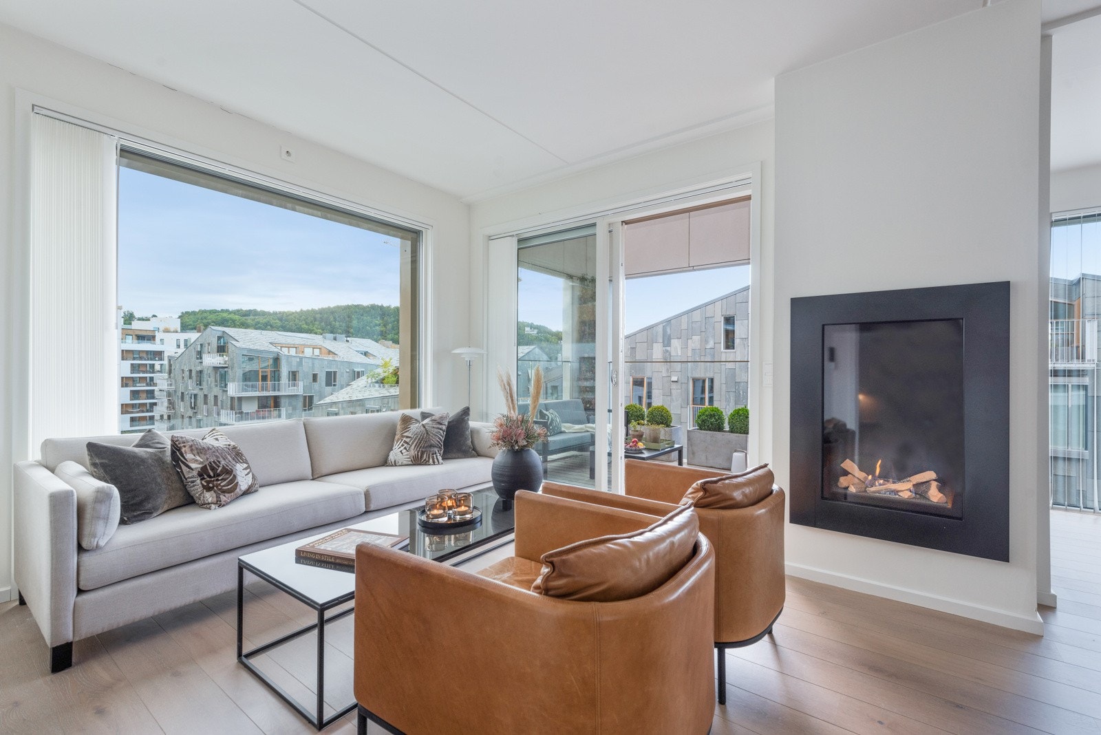 Med hjørnebeliggenhet og store vindusflater fra tak til gulv, får man flott lysinnslipp fra to sider i stuen Galleribilde