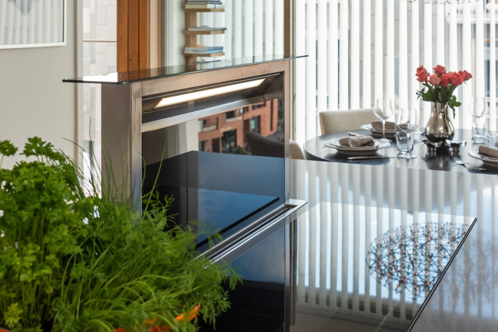 Platetopp med ventilator integrert i kjøkkenøyen. Elektrisk hev/senk funksjon Galleribilde