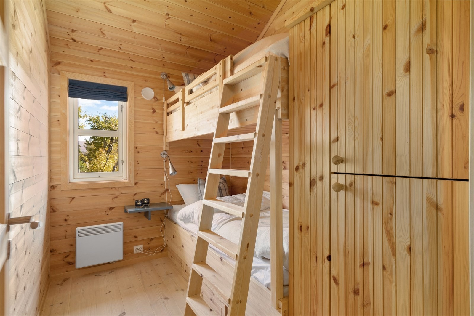 Soverom tre med plassbygd køyeseng, nattbord og garderobeskap. Fra den øverste sengen er det adkomst til hems. Artig løsning for de små Galleribilde