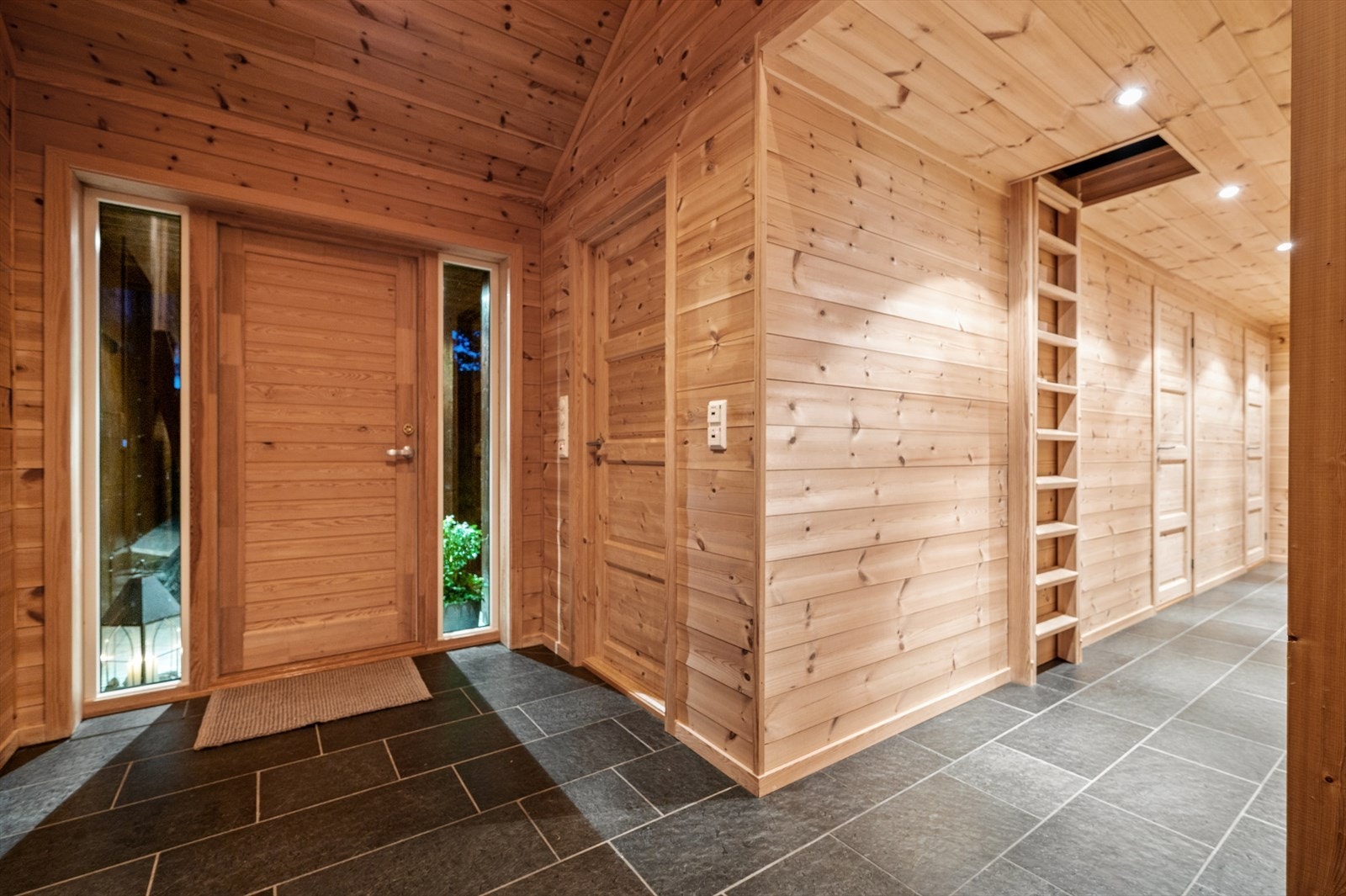 Romslig entré med gang som leder til vaskerom med wc, bad og 3 soverom. I rommet til høyre er det praktisk skibod Galleribilde