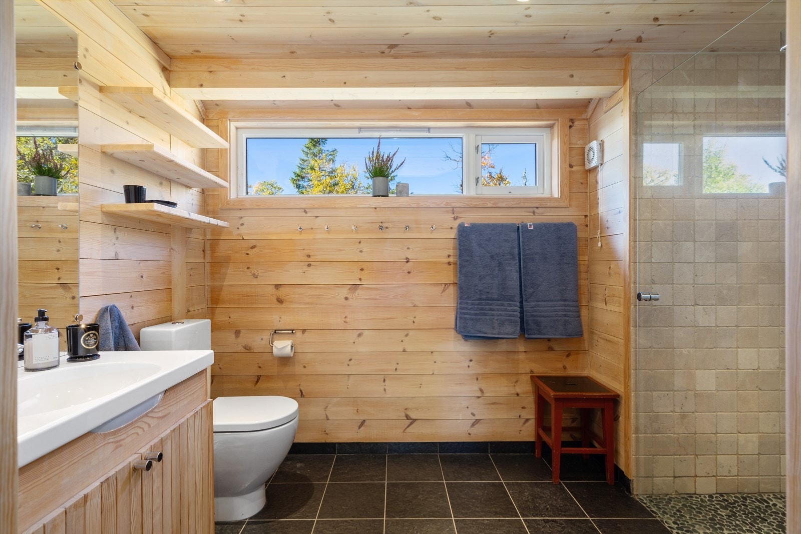 Romslig bad innredet med servant, toalett og dusj, samt badstue. Otta skifer på gulv med varme og porselen fra Italia. Plassbygde skap- og hyller Galleribilde