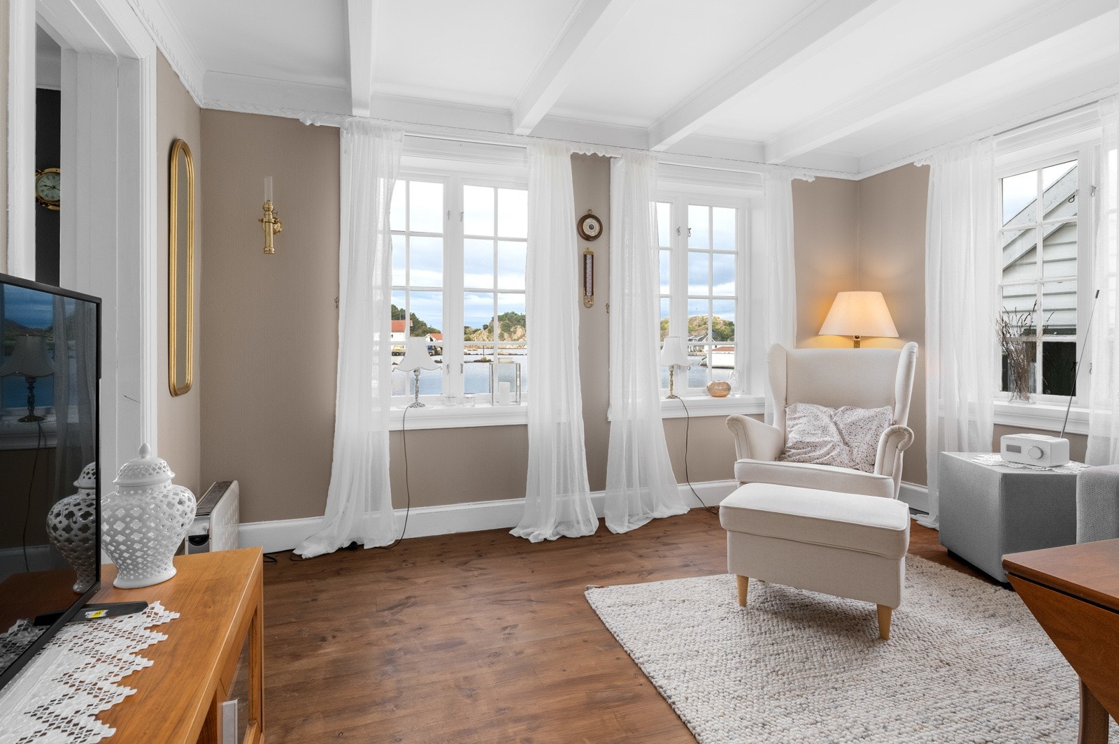 Stuen har store vinduer som slipper inn rikelig med naturlig lys Galleribilde