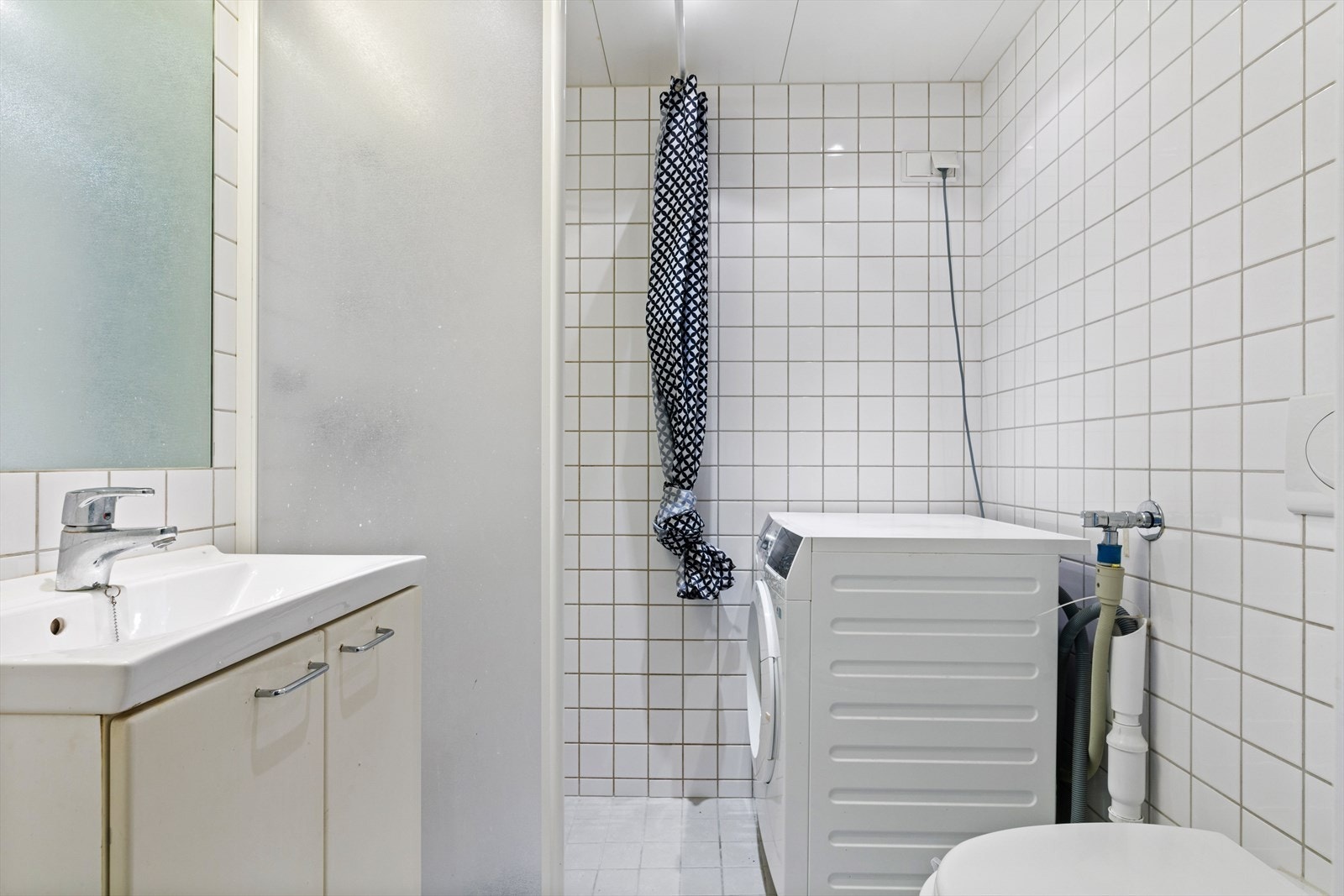 Bad med flislagte overflater, himling med downlights og gulvvarme. Opplegg for vaskemaskin. Galleribilde