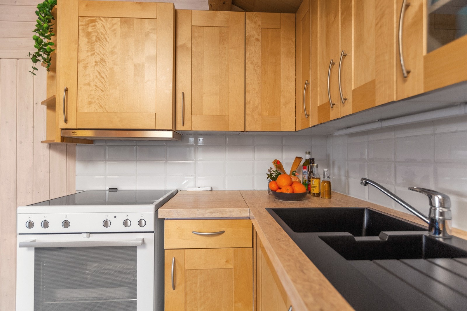 Det er flis mellom over- og underskap, laminat benkeplate med nedfelt kompositt vask. Galleribilde