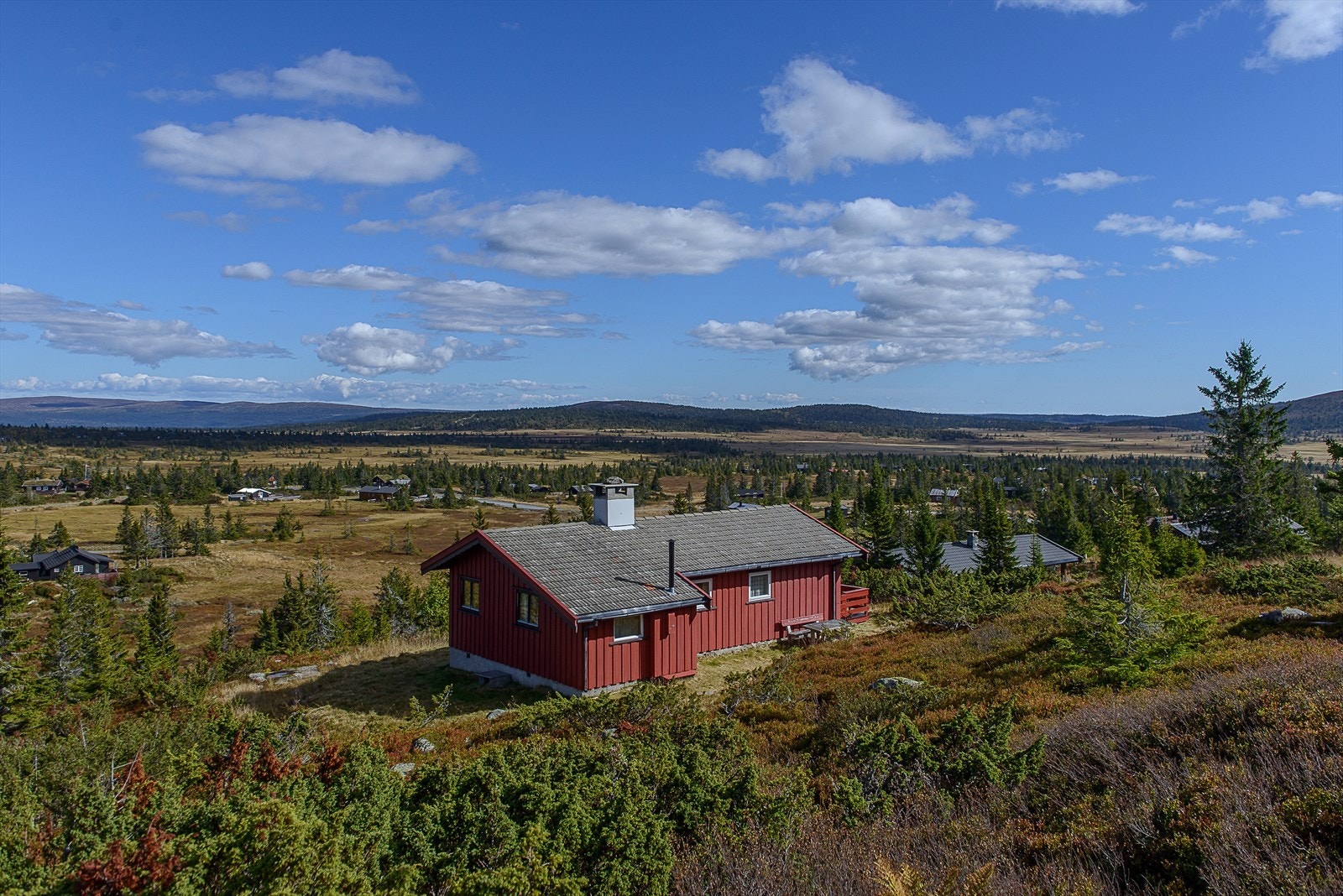 Hytta ligger i skrånende terreng i et veletablert hytteområde som ble fortettet med hyttebygging for noen år siden. Galleribilde