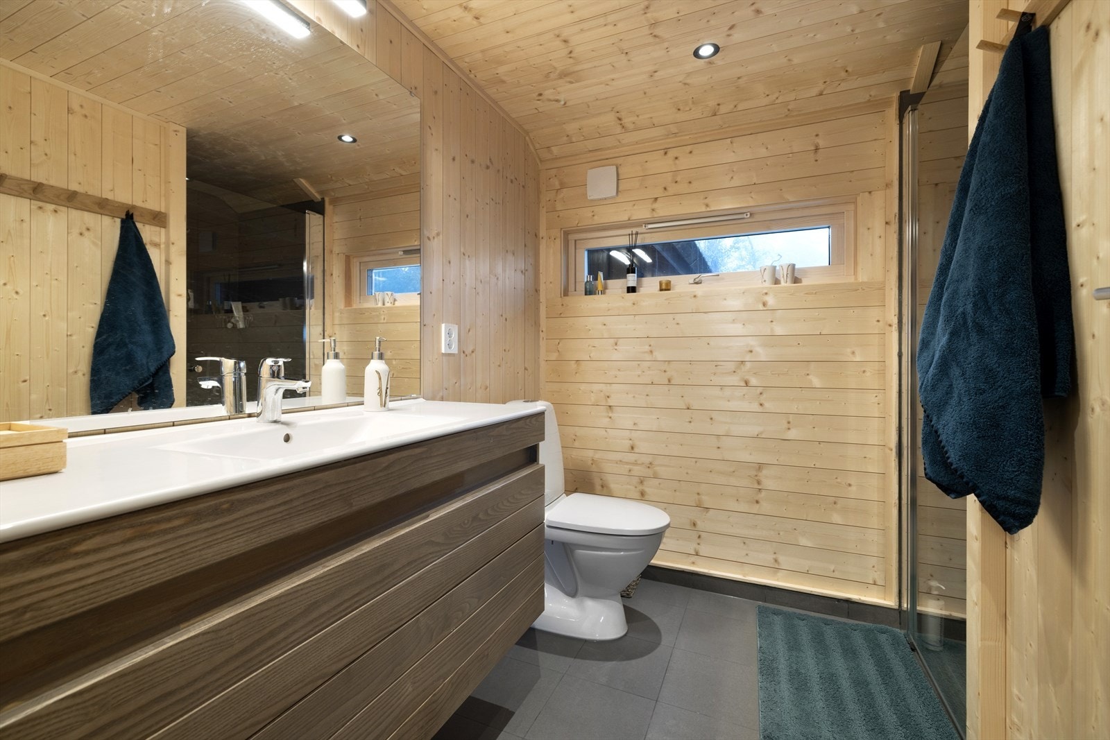 Hytta har et romslig bad med fliser på gulv og downlights i himling. Galleribilde