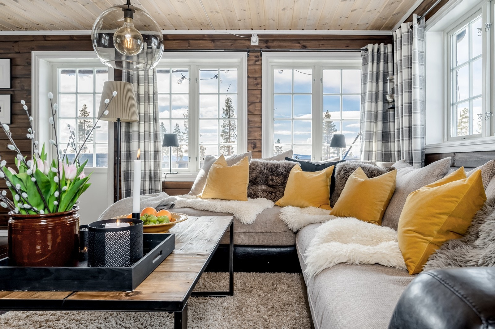 I stuen er det god plass til en romslig sofa foran peisvedovnen. Det helhetlige preget gir et godt rom å oppholde seg i. Galleribilde