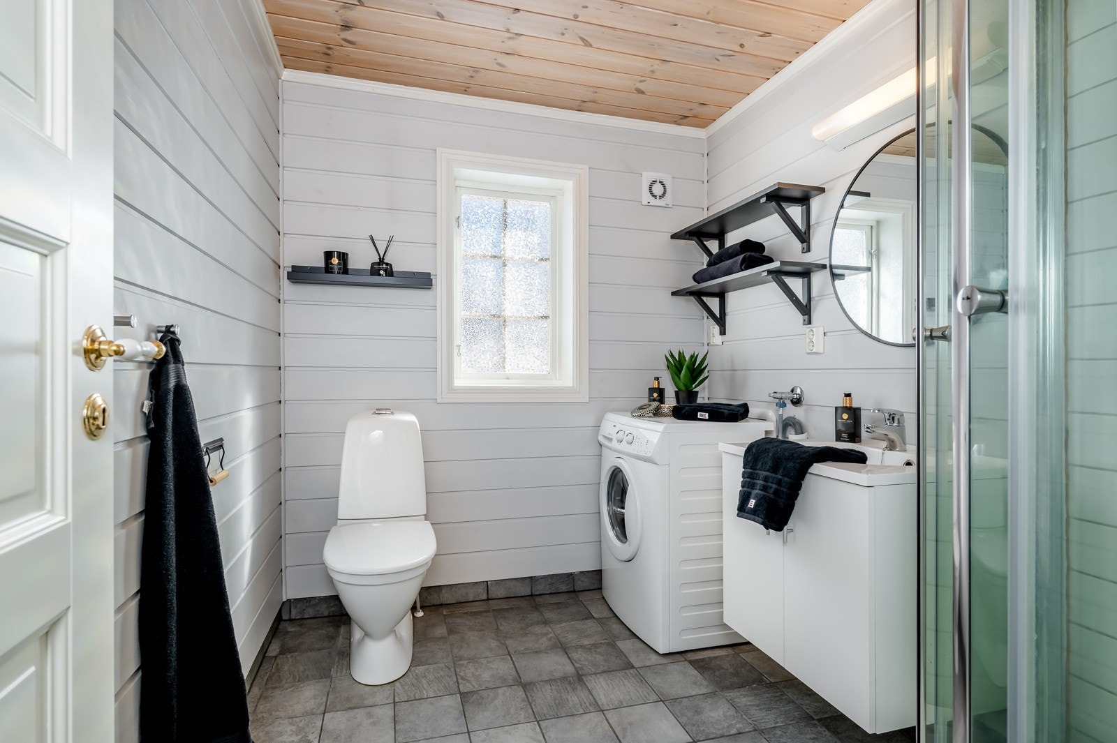Badet ligger godt plassert i hytta og har en pen fremtoning. Her er det flislagt gulv med varmekabler, lysmalt panel og vindu som slipper dagslyset fint inn. Galleribilde