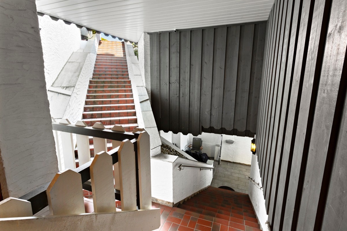 Det er utvendig støpte og flislagte trapper mellom garasjeplan og boligen, samt videre mot øvre platå i hagen. Galleribilde