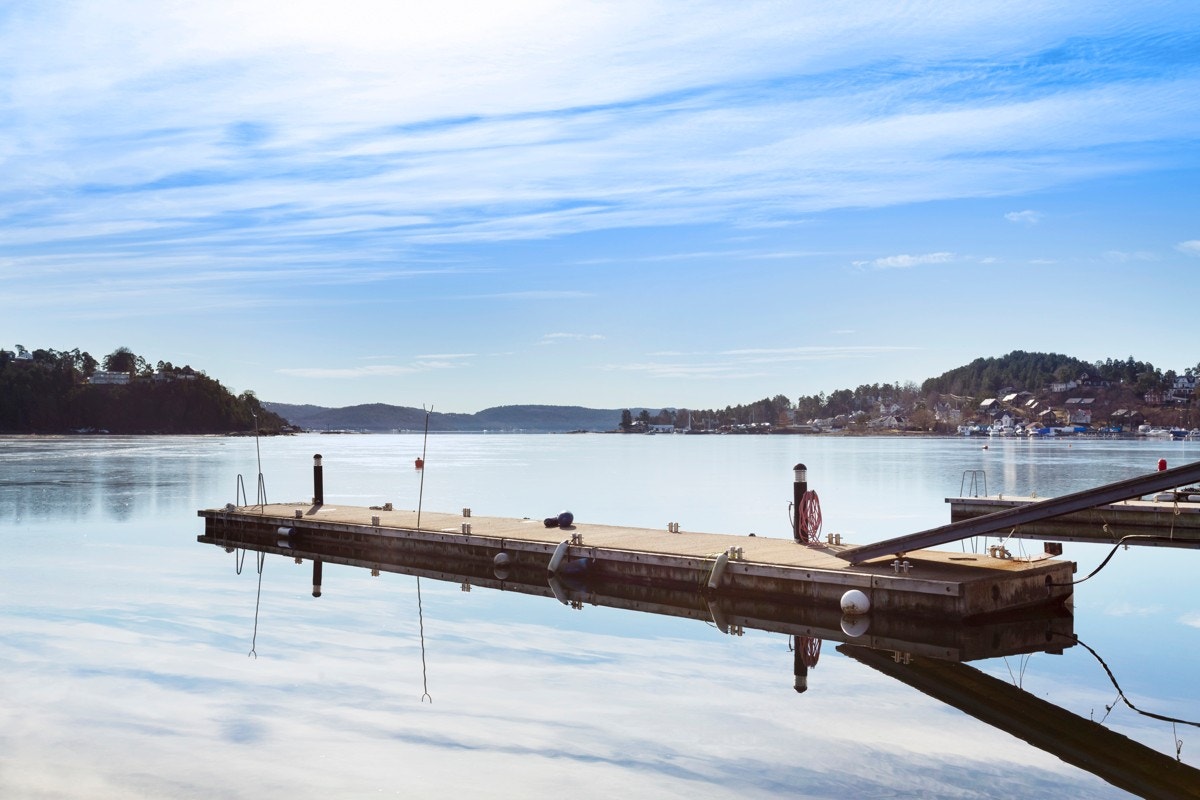 Boligen har tinglyst bruksrett til halvpart av strandparsell med brygge/båtplass. Det påpekes at det er kommet varsel om mulig ulovlighet på forlengelsen/flytebryggen fra plan- og bygningsetaten. Galleribilde