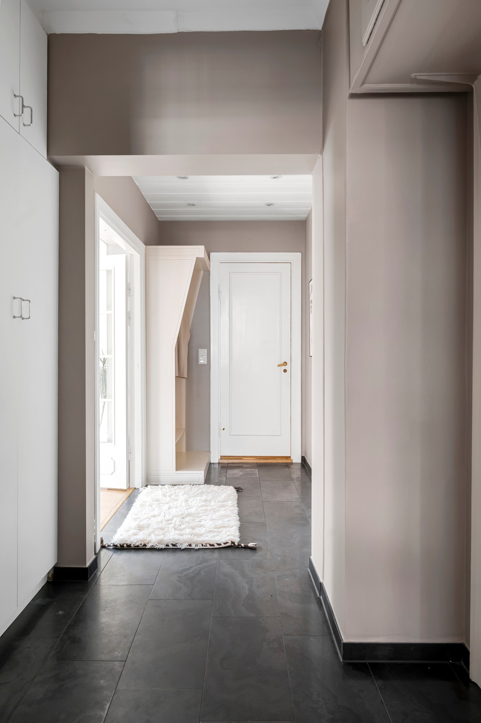 Entréen har god oppbevaringsplass i hvite garderobeskap, plassbygde overskap og en åpen, plassbygd garderobeløsning med hyller og heng. Galleribilde