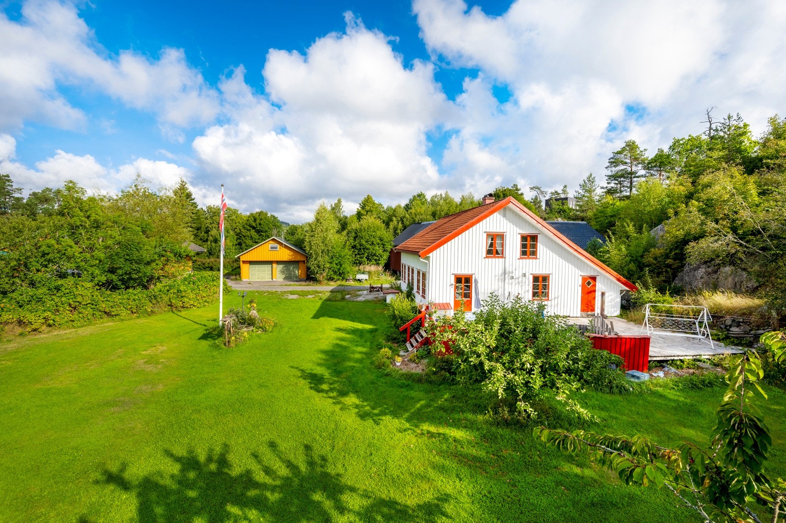 Idyllisk og landlig beliggenhet, gul garasje tilhører naboeiendom Galleribilde
