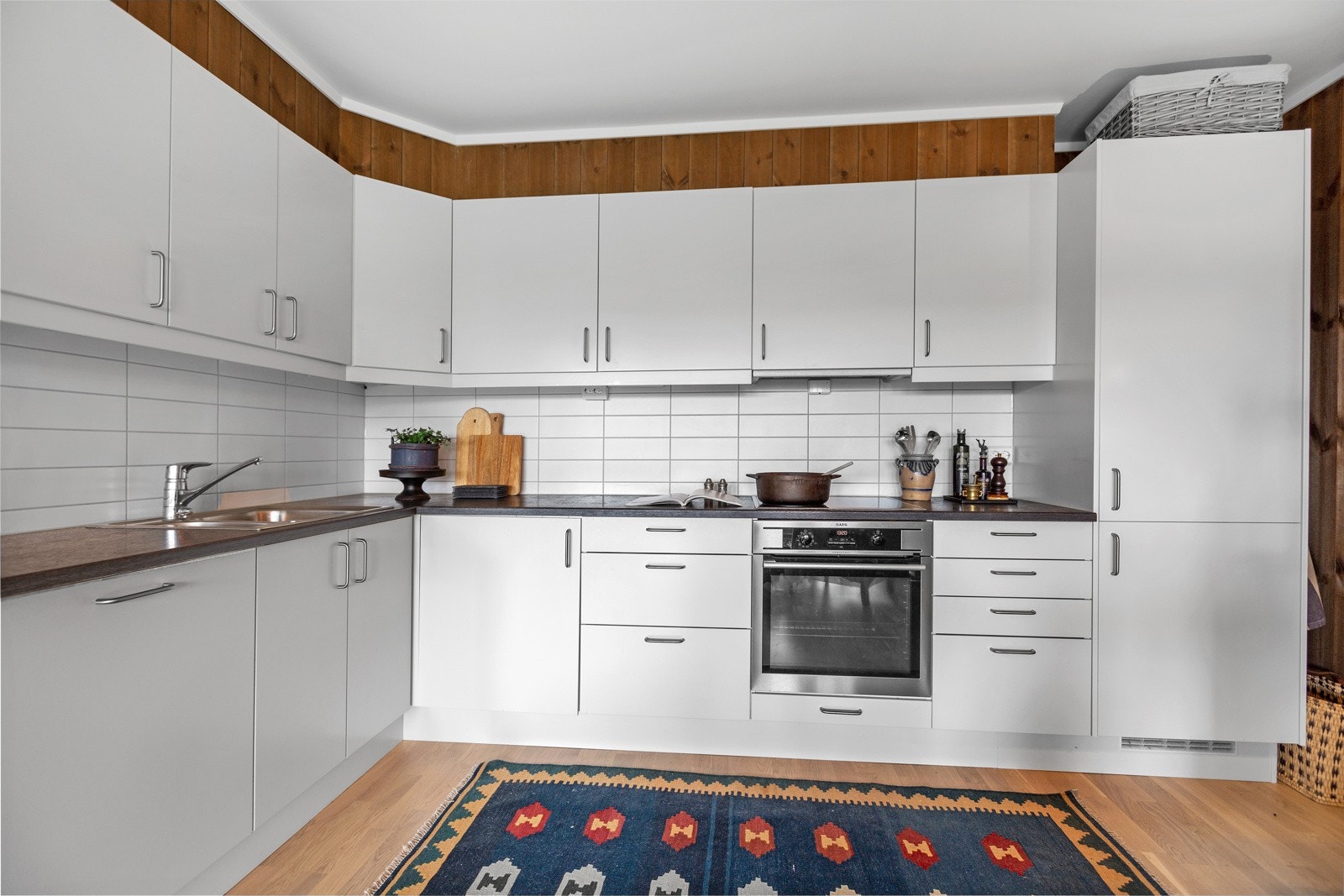 Innholdsrikt kjøkken med mye skap og benkeplass. Galleribilde