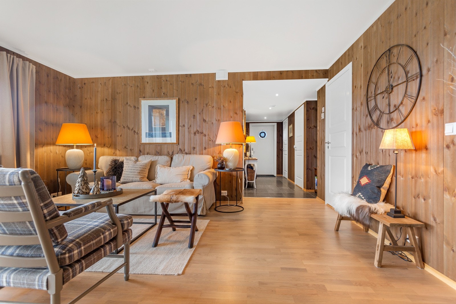 Mørkbeiset panel på veggene, laminat på gulv og hvit himling i stua. Galleribilde