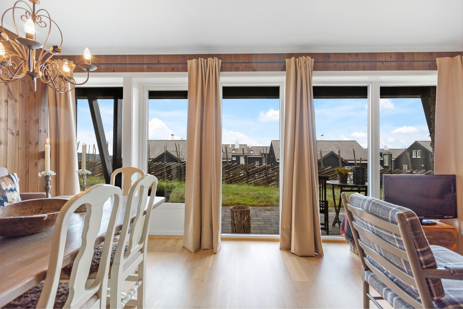 De store vinduene og verandadøren slipper inn godt med lys i rommet. Galleribilde