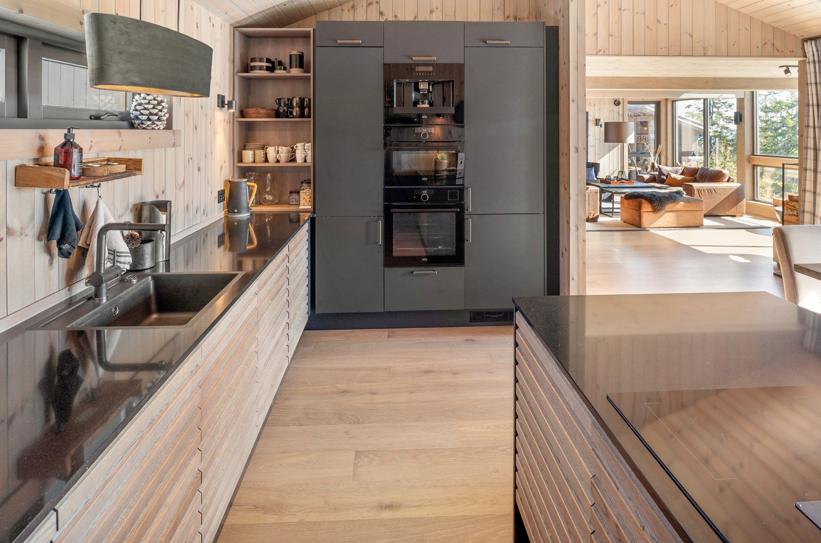 Kjøkkeninnredning med en kombinasjon av profilerte og slette fronter, laminerte skrog. Gode lagringsmuligheter i under- og høyskap. Benkeplater i stein. Galleribilde