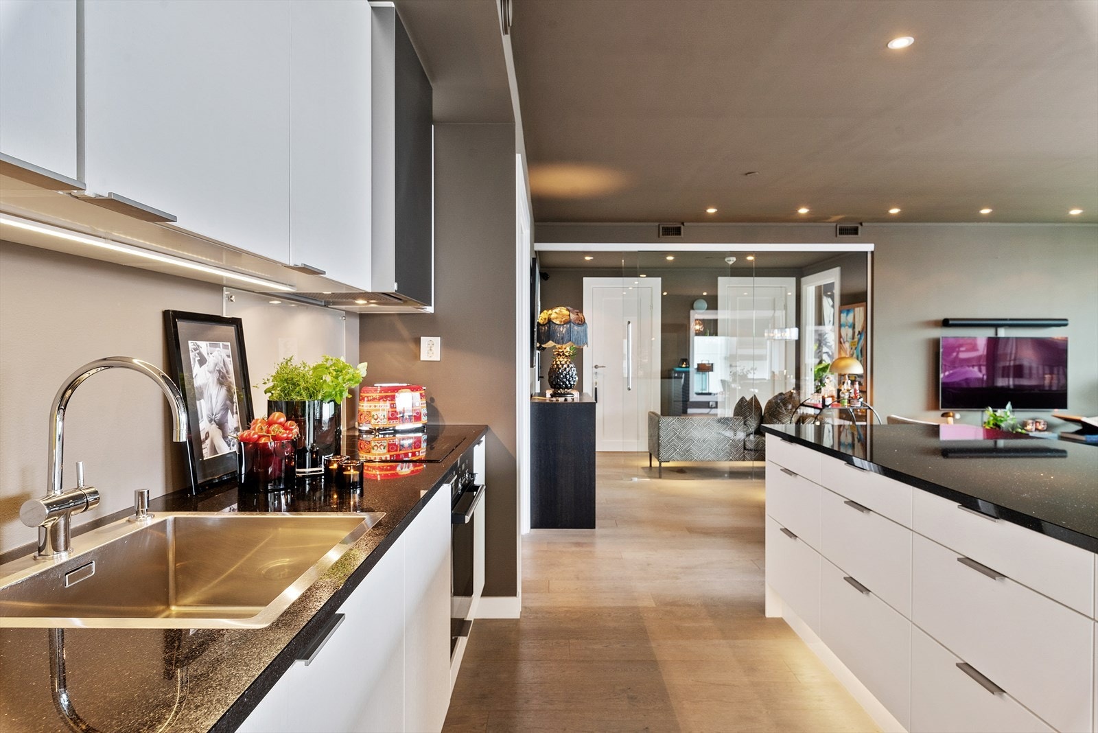 Pent kjøkken med stilren innredning og frittstående kjøkkenøy som gir godt med arbeidsplass. Galleribilde